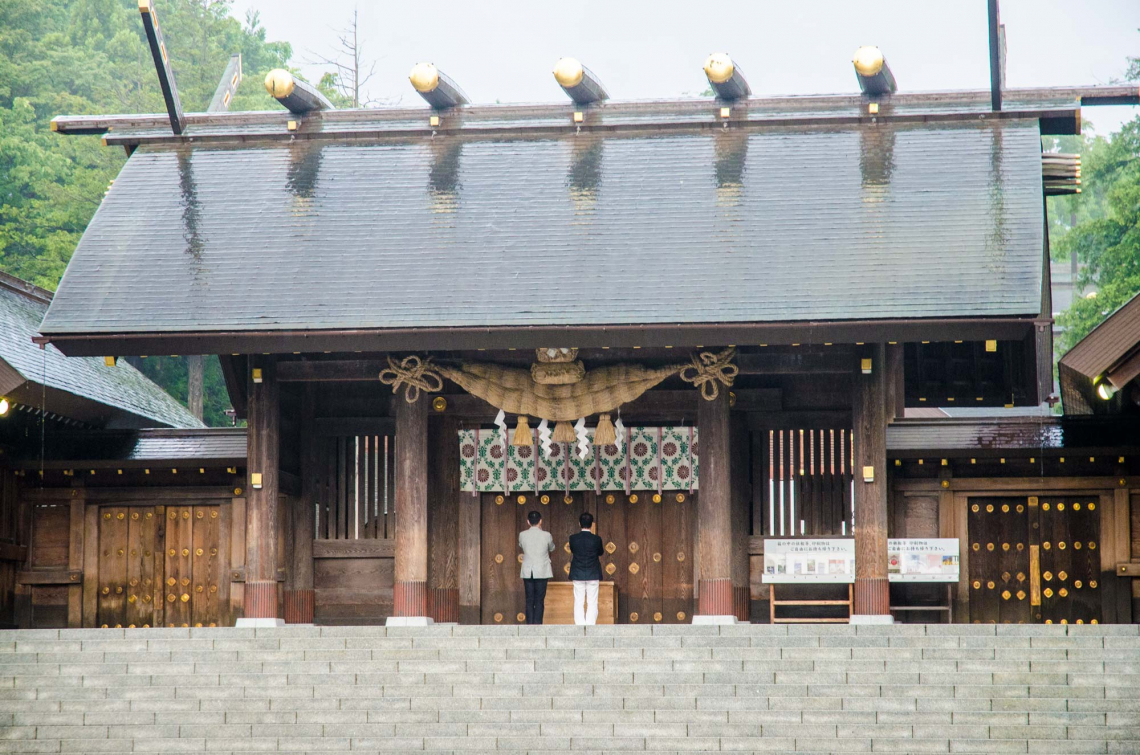 hokkaido jingu on a rainy day with 2 people praying